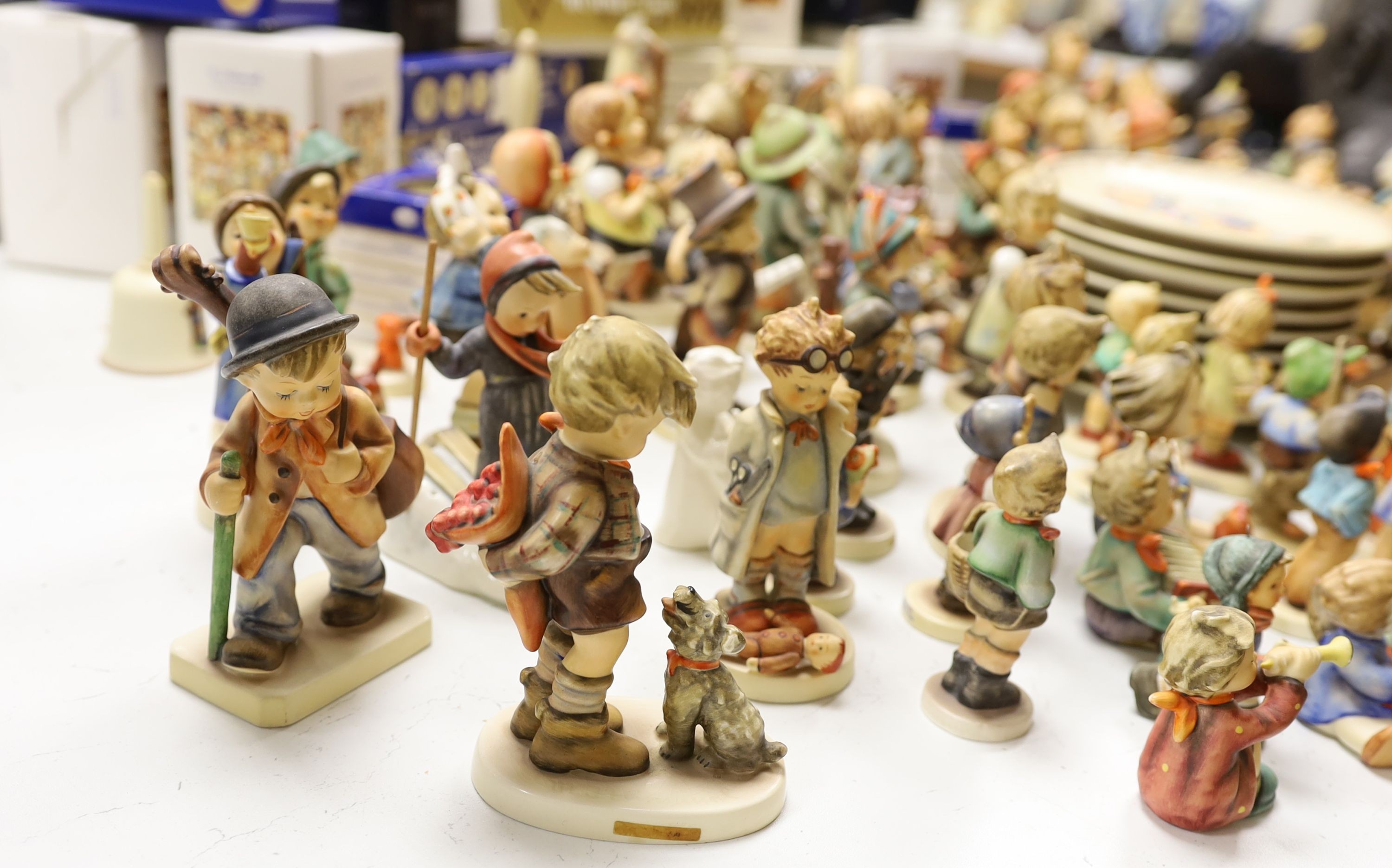 A large collection of Hummel pottery figures, approximately 70 including skier and two similar plaques, some with boxes.